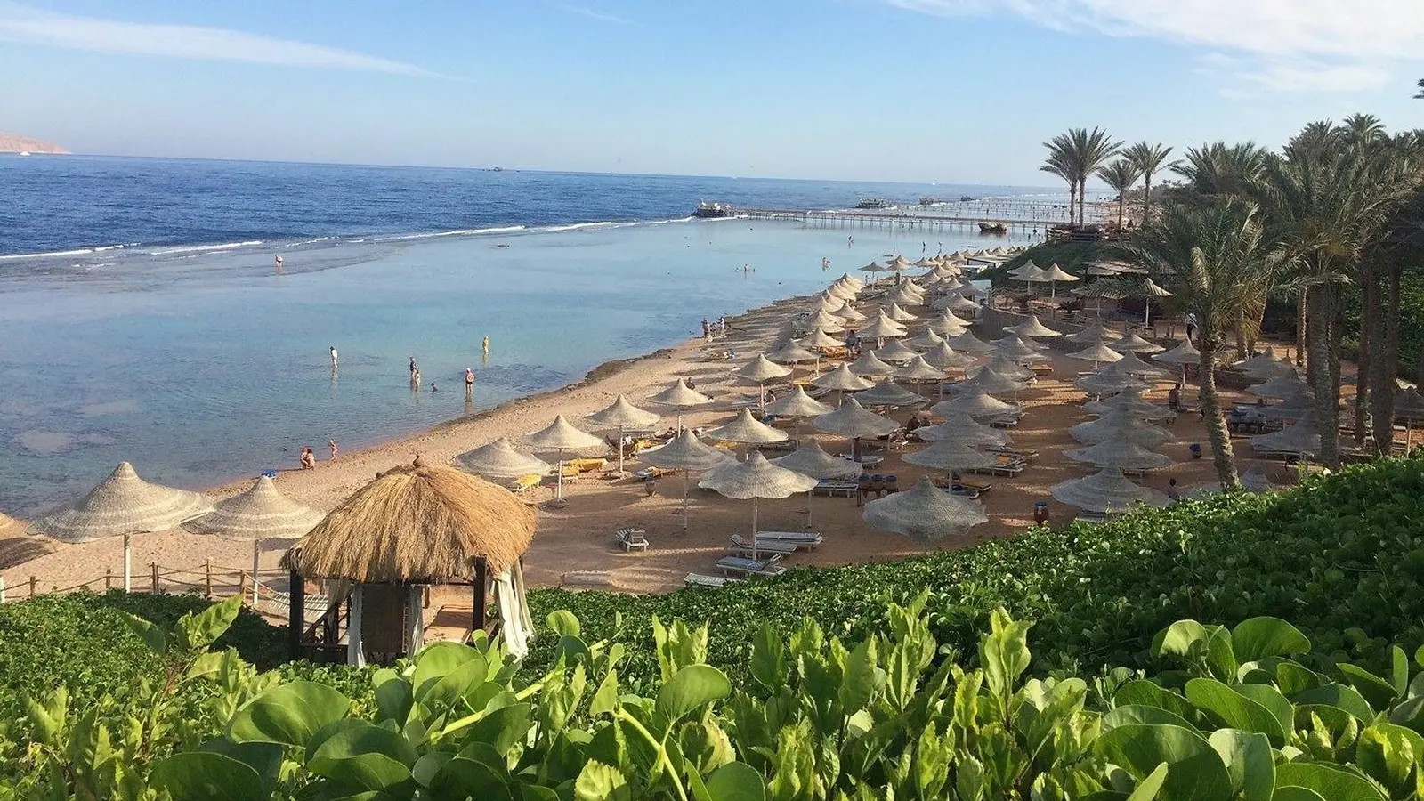 Nubian Island Hotel beach, Sharm El Sheikh — umbrellas, jetty and the Red Sea (photo: the hotel’s official website)