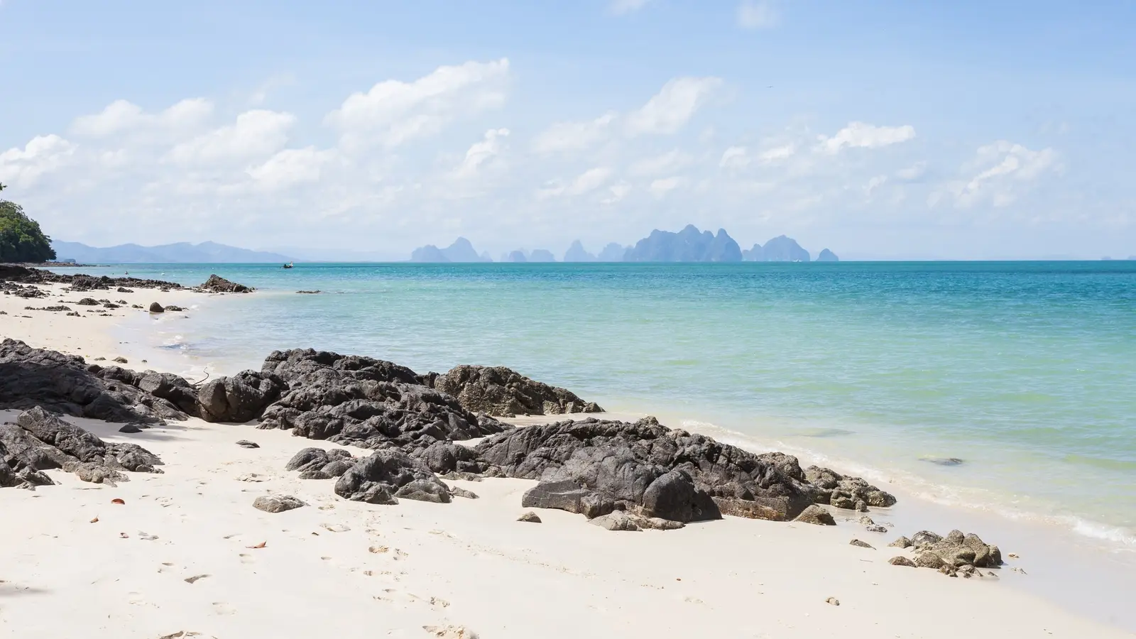 White-sand beach and turquoise sea in Phuket with karst islands on the horizon (photo: Diego Delso / Wikimedia Commons, CC BY-SA 3.0)